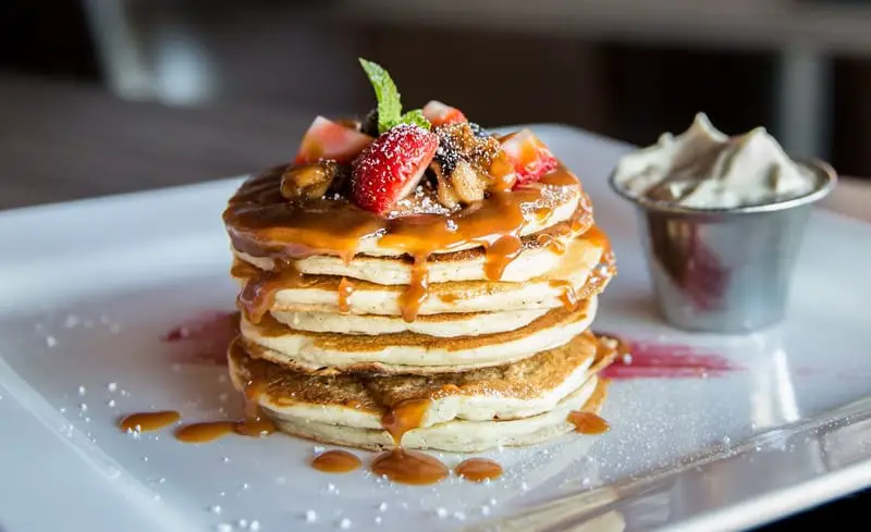 Eat Pancakes with fruits, berries, and chocolate sauce.